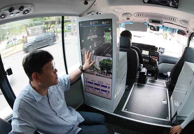 1일 서울 첫 자율주행 마을버스가 동작구 도로를 달리고 있다. 운전석에는 버스 기사 대신 안전 요원이 앉아 있다. 승객이 버스 안에 설치된 화면을 통해 운행 정보를 확인하고 있다./장경식 기자