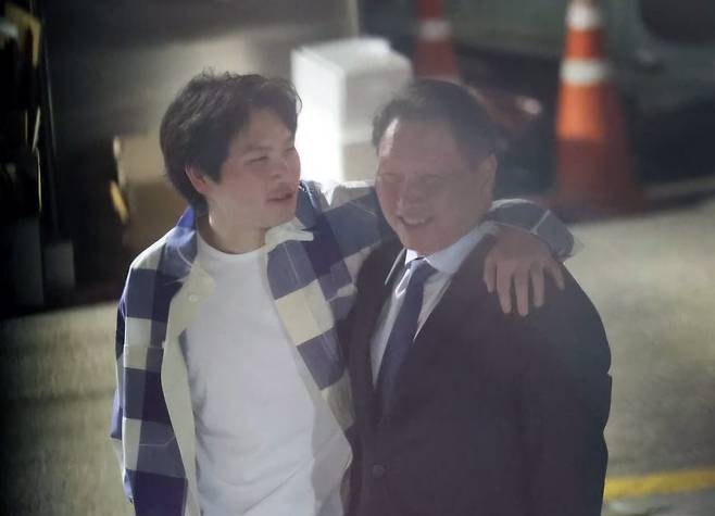 최태원(오른쪽) SK그룹 회장이 지난해 6월 서울 강남구 한 식당 앞에서 장남인 최인근 씨와 어깨동무를 하며 대화하고 있다./온라인 커뮤니티 캡처