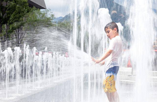 무더운 날씨 이어지면서 전국 대부분 지역에 폭염특보가 발효된 1일 서울 광화문광장 바닥분수대에서 한 외국인 어린이가 즐거운 시간을 보내고 있다. 연합뉴스