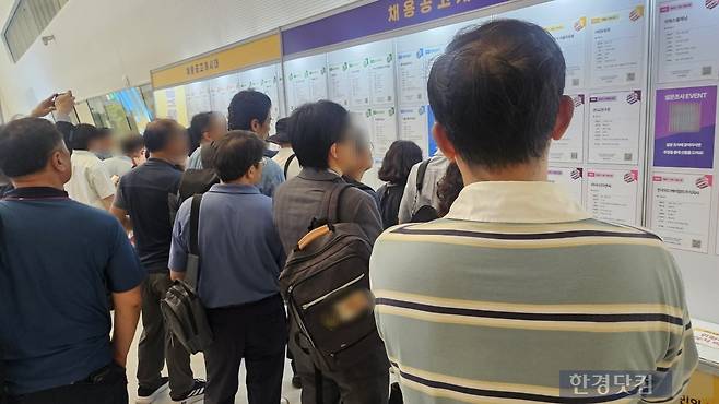 중장년 일자리 박람회에서 채용공고 게시판을 보고 있는 시니어 구직자들/사진=유지희 기자