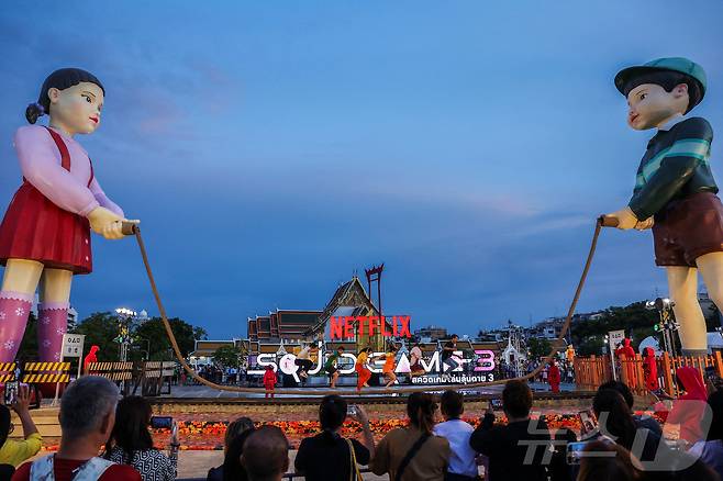 지난 30일(현지시간) 태국 방콩 시청 광장에서 열린 '오징어 게임 3' 홍보 행사에서 시민들이 줄넘기 게임을 하고 있다. ⓒ 로이터=뉴스1