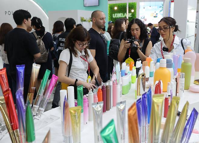 2일 서울 코엑스에서 열린 인터참코리아를 찾은 외국인들이 참가 부스의 화장품 등을 살펴보고 있다. 연합뉴스