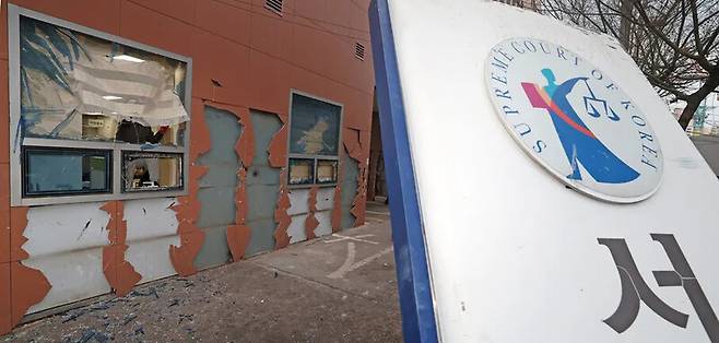 내란죄 피의자 윤석열 전 대통령의 구속 영장이 발부되자 윤 전 대통령의 지지자들이 서울 마포구 서울서부지법에 난입해 기물과 유리창 등을 파손한 지난 1월19일 오후 건설업자가 깨진 창문의 블라인드를 제거하고 있다. 김영원 기자 forever@hani.co.kr