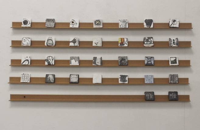 양희윤 作 ‘조각밥’ (2025, 타일, 퍼티, 수성흑연, 버리는 부자재들, 가변설치 (30점 각 5x5cm))