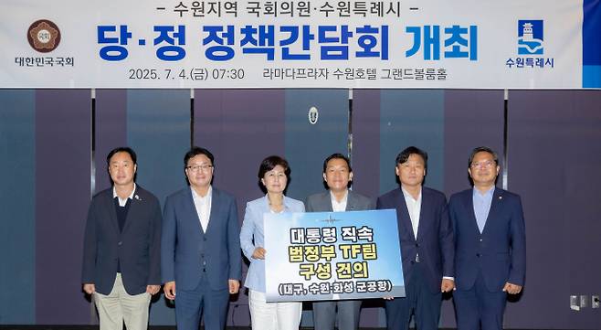 이재준 수원시장(왼쪽에서 4번째), 백혜련(3번째)·김영진(5번째)·김승원(6번째)·염태영(2번째)·김준혁(1번째) 의원이 '대통령 직속 범정부 군공항 이전 TF팀' 구성을 건의하는 내용이 담긴 팻말을 들고 기념촬영을 하고 있다./사진제공=수원시