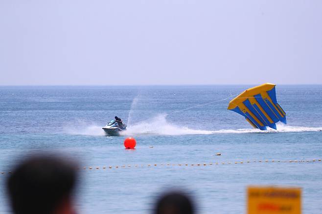 무더운 날씨를 보인 5일 강원 속초시 속초해수욕장에서 피서객들이 수상레저활동을 즐기고 있다. 연합뉴스