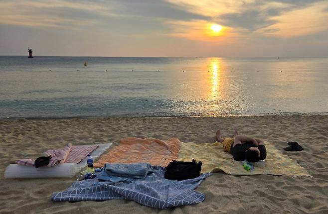 밤에도 기온이 식지 않는 열대야가 이어지면서 경포해변 백사장에서 잠을 자고 있는 모습. 연합뉴스