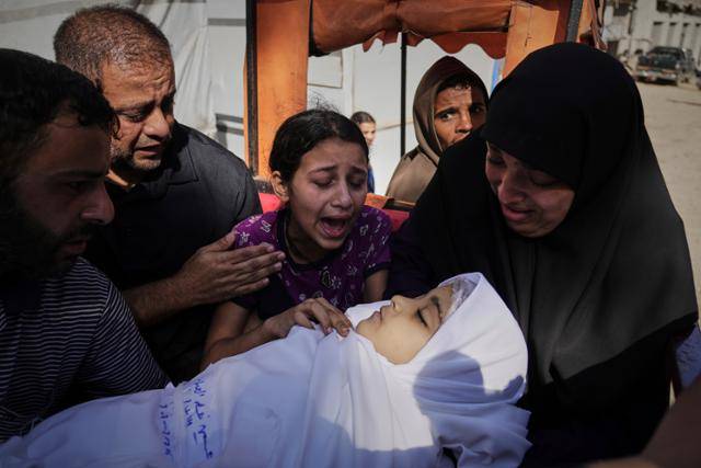 7일 가자시티에 떨어진 이스라엘 폭탄으로 사망한 팔레스타인 어린이 주변으로 가족들이 모여 슬퍼하고 있다. 가자시티=AP 연합뉴스