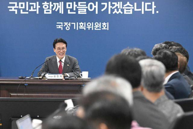 김민석(왼쪽) 국무총리가 7일 서울 종로구 정부서울청사 별관 국정기획위원회에서 전체회의 참석 위원들과 인사를 나누고 있다. 뉴시스