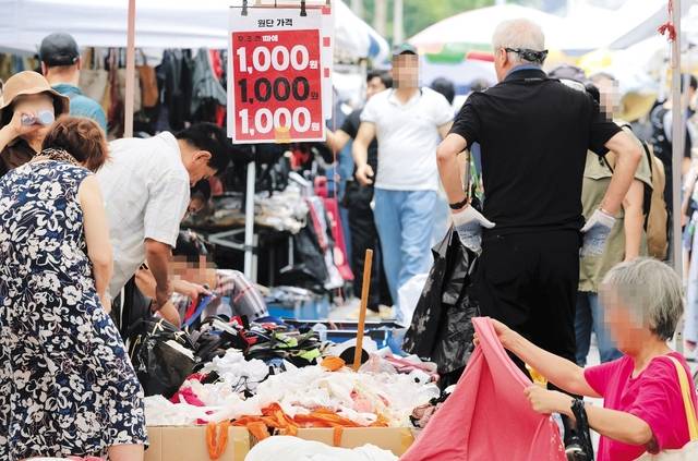 고물가·고금리가 이어지면서 생활비를 아끼기 위해 가격이 저렴한 상품을 찾아다니는 이들이 늘고 있다. 6일 서울 동대문구 평화상가 인근 동대문 일요시장을 찾은 시민들이 1000~2000원대의 저렴한 제품들을 살펴보고 있다. 연합뉴스
