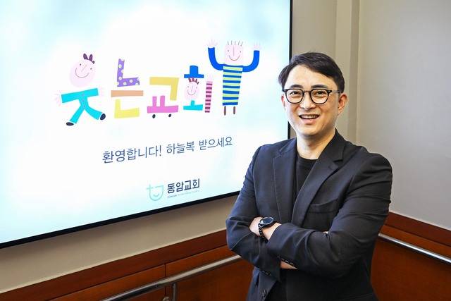 진대훈 동암교회 목사가 최근 서울 강동구 교회의 지하로 내려가는 계단에 켜진 ‘웃는교회’ 간판 앞에서 웃고 있다. 신석현 포토그래퍼