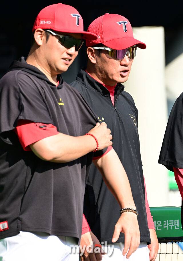 기아 손승락 수석코치가 김주찬, 김민우 코치에게 놀림(?)을 당한 뒤 자신의 유니폼을 만져보고 있다.