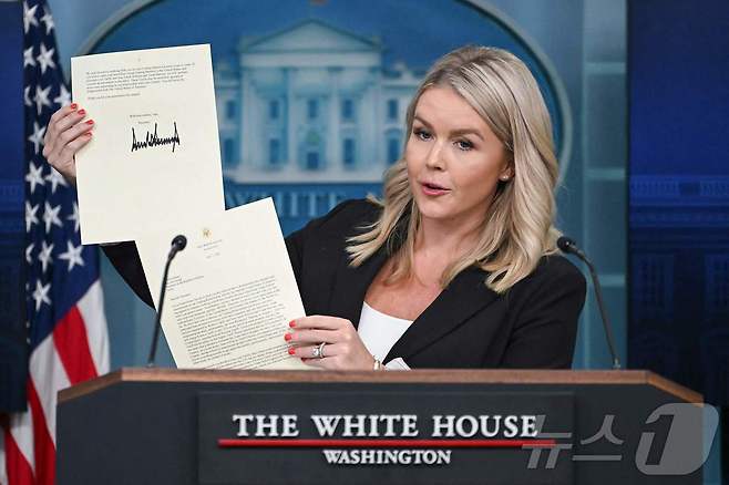 캐롤라인 레빗 백악관 대변인이 7일(현지시간) 미국 워싱턴 D.C. 백악관에서 열린 기자 회견에서 도널드 트럼프 미국 대통령이 이재명 대통령에게 보낸 관세 관련 서명 서한을 공개하고 있다. 트럼프 대통령은 이재명 대통령에게 보내는 서한에서 "불행히도 우리 관계는 상호적이지 않았다"면서 "2025년 8월 1일부터, 우리는 한국에서 미국으로 수출되는 모든 제품에 대해 품목별 관세와 별도로 25%의 관세를 부과할 것" 이라고 밝혔다. 2025.7.8 ⓒ AFP=뉴스1