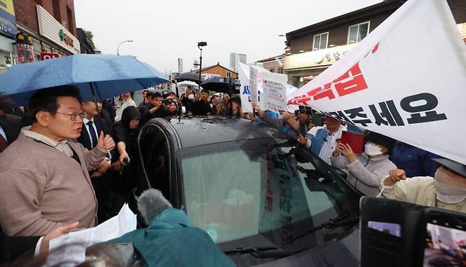 지난 5월 경북 고령에서 이재명 당시 민주당 대선후보가 대구 지역주택조합과 관련한 하소연을 듣고 있다. 연합뉴스