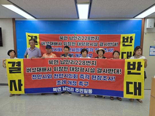 7일 천안시 북면 납안리 주민들이 천안시청 브리핑실에서 기자회견을 갖고 태양광 발전시설 설치를 반대하는 현수막을 펼쳐보이고 있다. 박하늘 기자