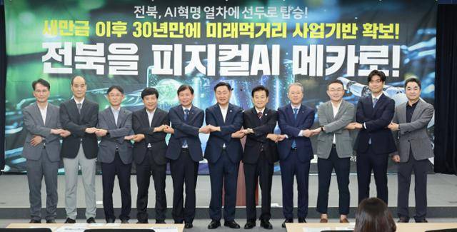 8일 전북도청 브리핑룸에서 '피지컬AI 국가전략사업 예산 확보' 기자회견이 끝난 뒤 김관영 전북지사, 정동영 국회의원, 이성윤 국회의원, 양오봉 전북대총장 등이 손을 맞잡고 기념 촬영을 하고 있다. 전북도 제공