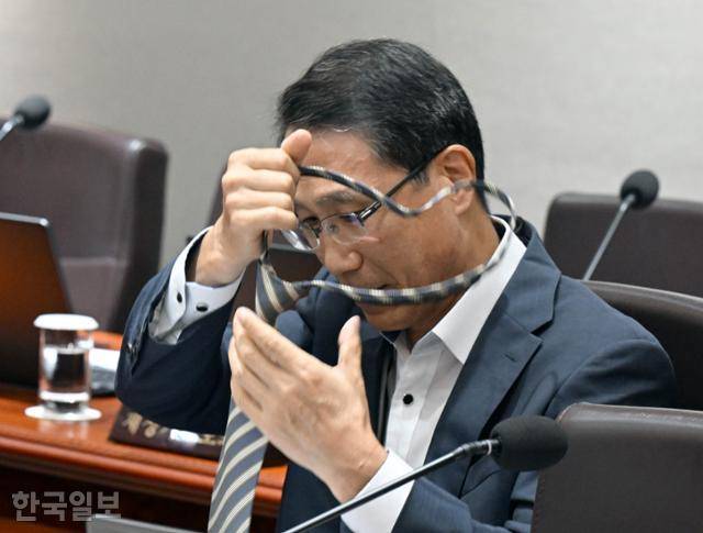 8일 대통령실에서 열린 국무회의에 참석한 유재성 경찰청 차장이 복장이 노타이 차림이라는 사실을 뒤늦게 알고 넥타이를 풀고 있다. 왕태석 선임기자