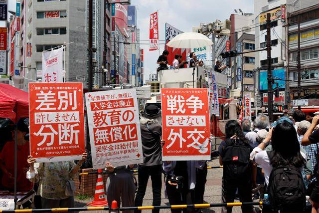 일본 공산당 당원들이 지난 3일 도쿄 도내 참의원 선거 유세 현장에서 '차별과 분열은 용서할 수 없다'고 적힌 플래카드를 들고 있다. 도쿄=EPA 연합뉴스