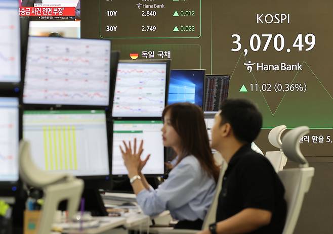 Officials work at a dealing room of Hana Bank in Seoul on Tuesday. (Yonhap)