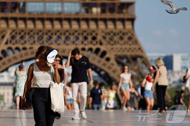 30일(현지시간) 찜통 더위 속 프랑스 파리 에펠탑 앞 광장을 관광객과 시민들이 지나고 있다. 2025.6.30 ⓒ AFP=뉴스1 ⓒ News1 이지예 객원기자