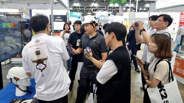 9일 아스가드사의 스마트 안전모를 방문객이 착용하고 있다. 머리 충격감지 경보, 블랙박스 기능 등이 탑재됐다. / 정다운 기자