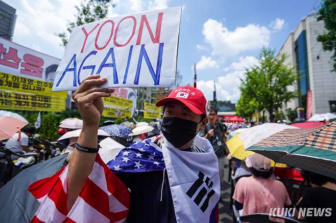 한 윤 전 대통령 지지자가 손팻말을 들고 이동하고 있다.
