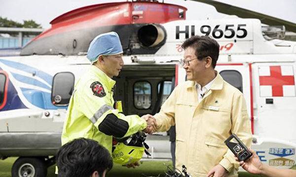 2019년 8월 경기도청 잔디광장에서 열린 ‘응급의료전용헬기 종합시뮬레이션 훈련’에서 이재명 대통령(오른쪽·당시 경기도지사)과 이국종 국군대전병원장(당시 아주대학교병원 권역외상센터장)이 악수하고 있다. 경기도 제공