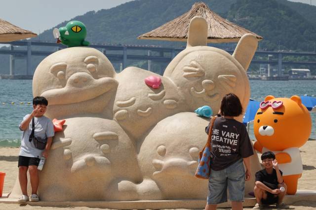 ‘프렌즈 모래성’을 배경으로 기념 사진을 남기는 관광객들