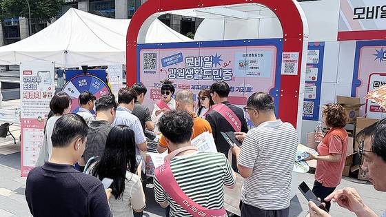 지난달 17일 서울 청계천에 마련된 강원생활도민증 발급 행사장을 찾은 이들이 모바일 도민증 발급에 참여하고 있는 모습. 사진 강원도