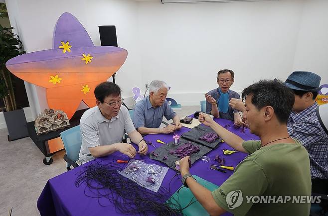 '10.29 이태원 참사, 함께 만드는 1000일' (서울=연합뉴스) 류영석 기자 = 12일 이태원 참사 기억소통공간인 서울 종로구 별들의집에서 유가족 등 참가자들이 오는 24일 참사 발생 1천일을 맞이하며 추모 목걸이를 함께 만들고 있다. 2025.7.12 ondol@yna.co.kr