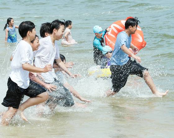 부산에 폭염경보가 발효 중인 4일 해운대해수욕장을 찾은 학생들이 시원한 바다에 뛰어들고 있다. 뉴시스