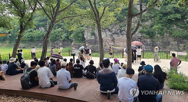 방문객으로 북적이는 반구대 암각화 (울산=연합뉴스) 허광무 기자 = 13일 울산 울주 대곡리 반구대 암각화 전망대에서 방문객들이 문화관광해설사의 설명을 듣고 있다. 반구대 암각화를 포함하는 '반구천의 암각화'는 지난 12일 유네스코 세계유산으로 등재됐다. 2025.7.13 hkm@yna.co.kr