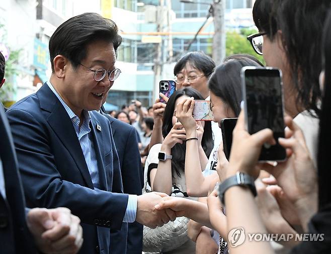 시민들과 인사하는 이재명 대통령 (서울=연합뉴스) 홍해인 기자 = 이재명 대통령이 11일 저녁 서울 광화문 인근 한식당 앞에서 시민들과 인사하고 있다. 이 대통령은 식당을 찾기 전 SNS에 식사 계획을 알리며 "민생회복 소비쿠폰 정책이 내수 진작과 지역경제 활성화에 활력을 불어넣길 기대한다"고 밝혔다. 2025.7.11 hihong@yna.co.kr