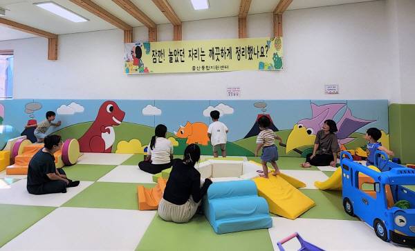 9일, 의성군 출산통합지원센터 베이비카페에서 공룡 그림이 삽입된 벽면 쿠션과 친환경 매트 위로 영유아와 보호자들이 함께 놀이활동을 하고 있다. 의성군