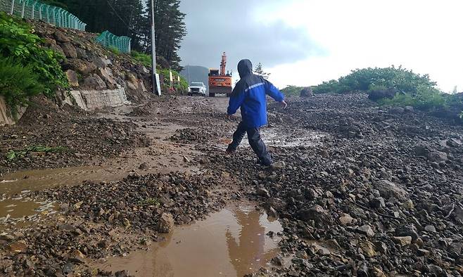 14일 경북 울릉군 북면 현포리 도로에 흙과 돌이 쏟아져 울릉군이 장비와 인력을 동원해 치우고 있다. 연합뉴스