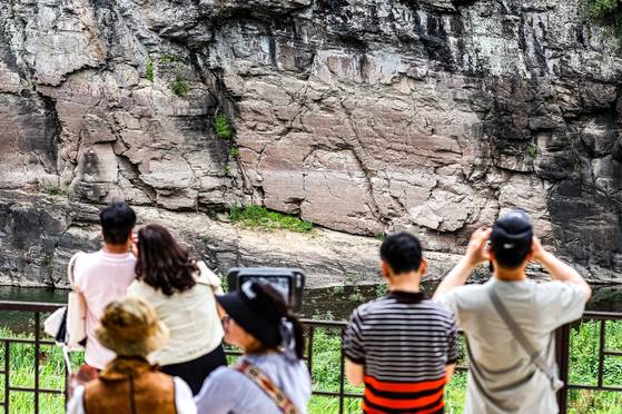13일 울산시 울주군 대곡리 반구대 암각화 전망대에서 시민이 망원경으로 암각화를 관람하고 있다. 지난 12일 '울주 대곡리 반구대 암각화'와 '울주 천전리 명문과 암각화'로 구성된 '반구천의 암각화'가 유네스코 세계유산으로 등재됐다. 연합뉴스