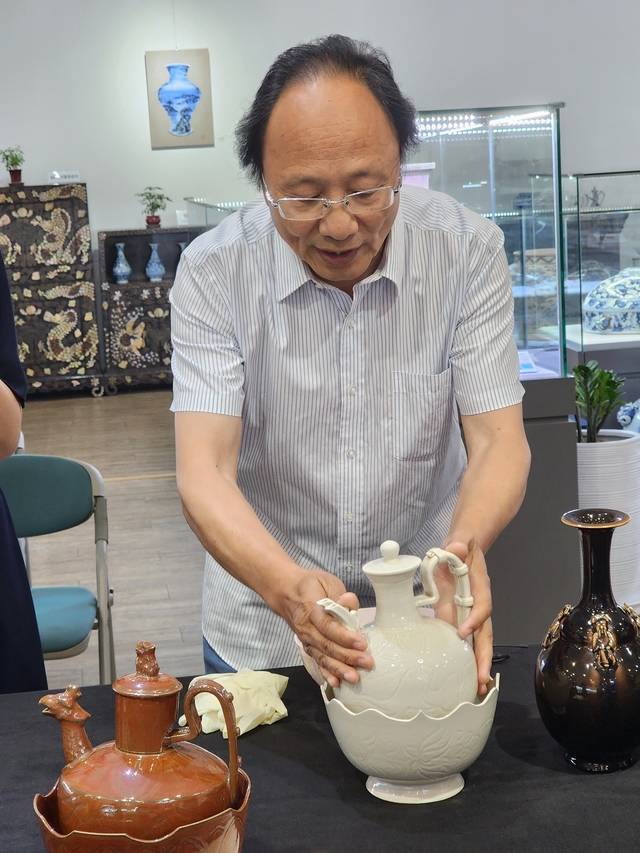 천커타오 상하이 소장협회 상무 부회장이 북송 연대의 정요 ‘관’ 모란문 주자 승반(北宋 定窯 ‘官’款 牡丹紋 執壺 承盤)을 어루만지며 살피고 있다.