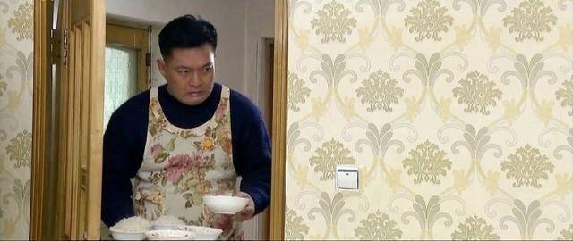 조선중앙TV 드라마 ‘백학벌의 새봄’ 속 남성이 꽃무늬 앞치마를 입고 아내와 딸에게 밥을 차려주고 있다. 조선중앙TV 캡처, 연합뉴스