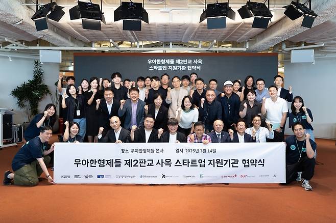 지난 14일 서울 송파구 롯데월드타워 '더큰집'에서 스타트업 육성 지원사업 참여 기업 및 기관 관계자들이 '스타트업 투자와 육성을 위한 액셀러레이션 공동사업 업무제휴 협약'을 맺고 기념촬영을 하고 있다. 〈자료 우아한형제들〉