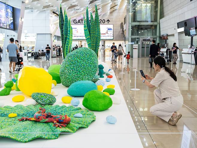 15일 김포공항 국내선 3층에 전시된 정찬부 작가의 작품 ‘피어나다’를 공항이용객이 감상하고 있다.