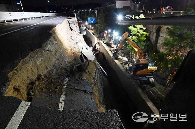 수도권 등 중부지역에 호우주의보가 발효된 16일 오후 오산시 가장교차로 고가도로 옹벽이 무너져 소방관들이 매몰된 차량을 구조작업하고 있다. 김경민기자