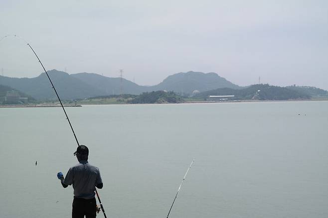 6월22일 전북 고창군 구시포항 방파제에서 낚시하는 낚시꾼 너머로 한빛원전이 보인다. 천경석 기자