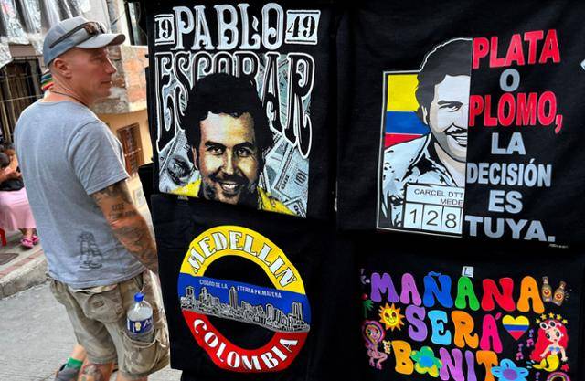 지난해 11월 25일 콜롬비아 메데인 지역에서 한 남성이 1993년 경찰에 사살된 '마약왕' 파블로 에스코바르의 이미지가 인쇄된 기념품 홍보물 앞을 지나가고 있다. 에스코바르는 마약 범죄 조직 '메데인 카르텔'을 이끌었던 인물이다. 메데인=AFP 연합뉴스