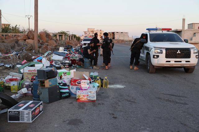 시리아 정부군이 15일 시리아 남부 마즈라 마을 검문소에서 드루즈족 민병대로부터 압수한 물품 옆에 서 있다. 마즈라=AP 연합뉴스