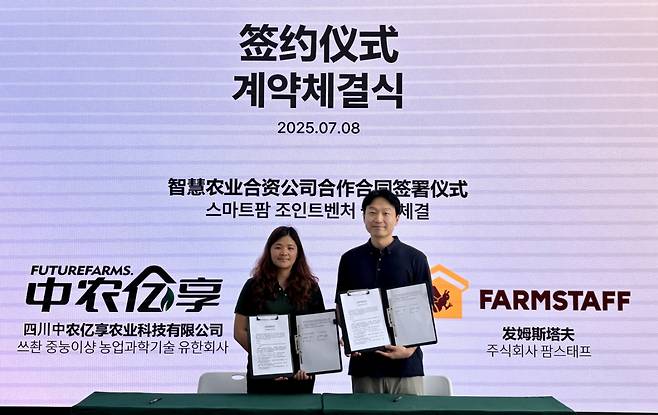김정우 팜스태프 대표와 펑지에(Peng jie) 중농이샹 대표가 업무협약을 맺고 있다. /사진=팜스태프 제공