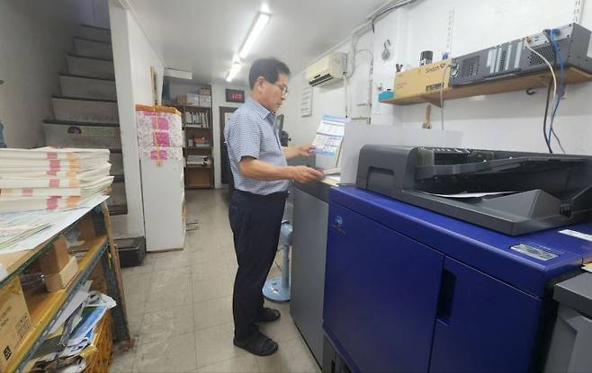 서울 충무로 인쇄골목에서 인쇄소를 운영하고 있는 이해욱씨가 출력물을 검수하고 있다. 변선진 기자