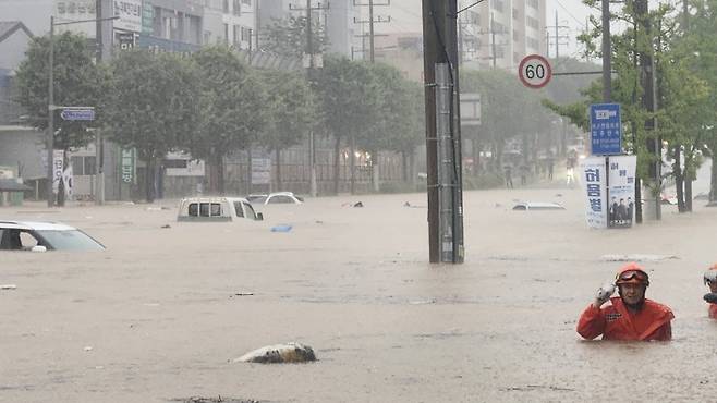 17일 오후 집중호우로 광주 북구 신안동을 흐르는 서방천이 범람하면서 인근 도로가 완전히 침수됐다. 구조대원들이 차량이 물에 잠긴 도심 한복판에서 구조 작업을 벌이고 있다. 독자 제공