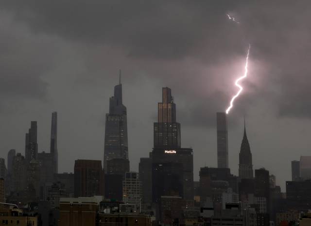 14일(현지시간) 뉴욕시에서 천둥번개가 치는 가운데 맨해튼 스카이라인의 원 월드 트레이드 센터 첨탑에 번개가 치고 있다. UPI연합뉴스