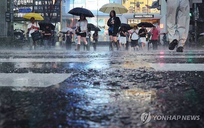 굵어지는 빗줄기 (서울=연합뉴스) 이진욱 기자 = 비가 내리는 16일 서울 강남역 인근에서 시민들이 우산을 쓴 채 이동하고 있다. 이날 기상청은 중부지방과 호남을 중심으로 많은 비를 예보했다. 2025.7.16 cityboy@yna.co.kr