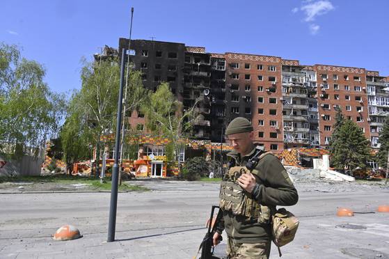 우크라이나 도네츠크 지역 포크로우스크 중심부에서 우크라이나 군인이 파괴된 건물들 앞을 지나가고 있다. AP=연합뉴스